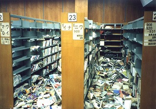 床一面に本が散乱した市立図書館閲覧室